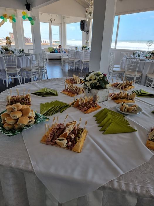 Mesa de finger food con sándwiches y picada