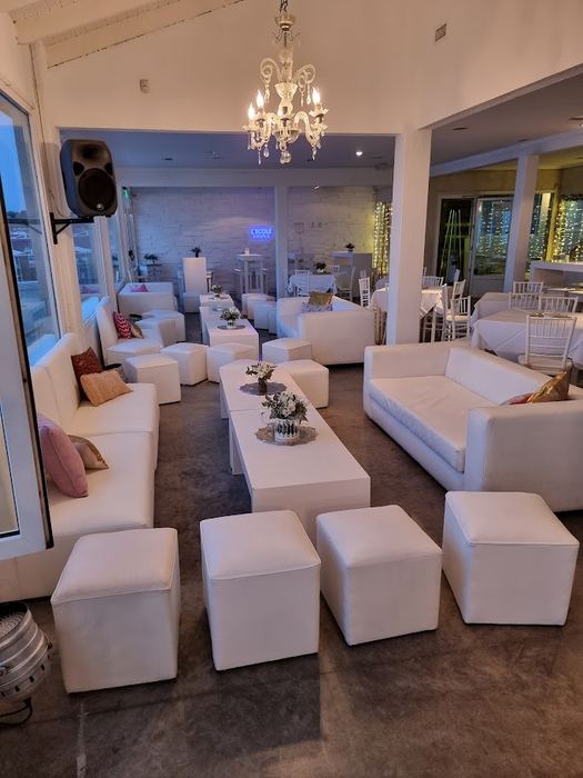 Living con sillones blancos y araña de cristal